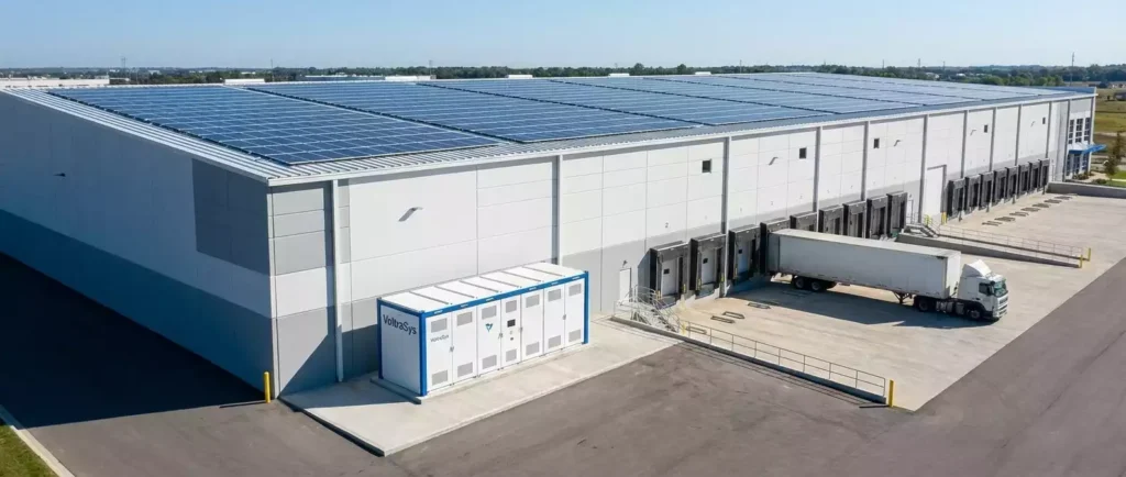 Custom Peak Shaving & Load Shifting Solution for System Integrators & Industrial Facilities 5 Outdoor installation of VoltraSys 100kWh industrial energy storage cabinet at a large logistics warehouse. The system integrates with rooftop solar panels for a complete solar-plus-storage solution, enabling warehouse peak shaving and reducing carbon footprint.